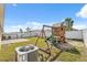 Backyard with a playhouse, swing set, and patio area, enclosed by a white privacy fence at 35592 Stella Vast Dr, Zephyrhills, FL 33541