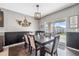 Dining room featuring a long wooden table, stylish light fixture, and sliding glass doors to the patio at 35592 Stella Vast Dr, Zephyrhills, FL 33541