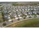 Aerial view of a Gathering-friendly neighborhood featuring modern homes, tree-lined streets, and well-maintained lawns at 3991 Mellon Dr, Odessa, FL 33556