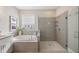 Bright bathroom featuring a soaking tub, glass-enclosed shower, and modern fixtures at 3991 Mellon Dr, Odessa, FL 33556