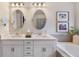 Elegant bathroom featuring a double vanity, framed artwork, and a luxurious soaking tub at 3991 Mellon Dr, Odessa, FL 33556