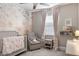 Serene Bedroom with floral wallpaper, a cozy armchair, and a crib with a plush blanket at 3991 Mellon Dr, Odessa, FL 33556