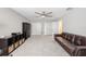 Neutral bonus room featuring a brown leather sofa, ceiling fan, two closets and a door to another room at 3991 Mellon Dr, Odessa, FL 33556
