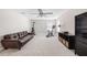 Bonus room with a brown leather sofa, exercise equipment, and a shelving unit with storage baskets at 3991 Mellon Dr, Odessa, FL 33556
