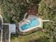 Aerial view of the community pool with ample lounge chairs, tables, and lush greenery, perfect for outdoor relaxation at 3991 Mellon Dr, Odessa, FL 33556