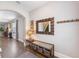 Welcoming entryway with hardwood floors, decorative mirror, and bench with storage baskets at 3991 Mellon Dr, Odessa, FL 33556
