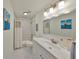 Bright bathroom featuring a single sink vanity, a large mirror, and a shower-tub combo at 413 Islebay Dr, Apollo Beach, FL 33572