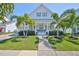 Charming two-story home with a landscaped yard, inviting front porch, and light blue shutters at 413 Islebay Dr, Apollo Beach, FL 33572