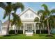 Charming two-story home with a manicured lawn and tropical palm trees surrounding the property at 413 Islebay Dr, Apollo Beach, FL 33572