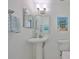 Stylish half bathroom with pedestal sink, modern fixtures, and coastal decor at 413 Islebay Dr, Apollo Beach, FL 33572