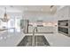 Bright, open kitchen featuring stainless steel appliances, white cabinetry, and a large center island with sink at 413 Islebay Dr, Apollo Beach, FL 33572