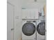 Modern laundry room with white cabinetry, and front loading washer and dryer at 413 Islebay Dr, Apollo Beach, FL 33572