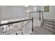 Bright staircase with white railings and a view of the modern kitchen below at 413 Islebay Dr, Apollo Beach, FL 33572