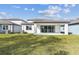 Back of the home with a large yard, perfect for outdoor activities, and covered patio for entertaining at 4255 Big Sky Dr, Spring Hill, FL 34604