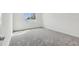 Bright bedroom with a large window and plush gray carpeting at 4255 Big Sky Dr, Spring Hill, FL 34604