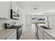 Modern kitchen featuring stainless steel appliances and sleek countertops with access to the backyard at 4255 Big Sky Dr, Spring Hill, FL 34604