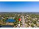 Aerial view of a house next to a lake surrounded by trees and a road in a neighborhood at 4322 22Nd N Ave, St Petersburg, FL 33713