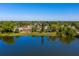 An aerial view of a lakeside neighborhood showcasing a home with an orange tile roof and screened in porch at 4322 22Nd N Ave, St Petersburg, FL 33713