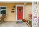 Close-up of a vibrant red front door with decorative welcome mat and plants at 4322 22Nd N Ave, St Petersburg, FL 33713