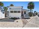 Charming single-story home with a red door, covered porch, palm trees, and landscaped front yard at 4851 W Gandy Blvd # B7L9, Tampa, FL 33611