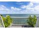 An ocean view from a balcony framed by greenery and white railings at 4966 Coquina Key Se Dr # 4966, St Petersburg, FL 33705