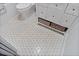 Bathroom detail showcasing the tile flooring, a toilet, and a vanity with wicker basket storage at 4966 Coquina Key Se Dr # 4966, St Petersburg, FL 33705