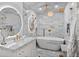 Beautiful bathroom with marble walls, soaking tub, glass shower, and dual vanities at 4966 Coquina Key Se Dr # 4966, St Petersburg, FL 33705