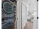 Convenient laundry area with a modern washer/dryer and storage shelves, plus a view of the bedroom at 4966 Coquina Key Se Dr # 4966, St Petersburg, FL 33705