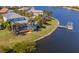 Aerial view showcasing a waterfront property with pool, dock, and lush landscaping at 5321 Fishersound Ln, Apollo Beach, FL 33572
