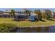 Waterfront property with screened-in pool, lush landscaping, and private dock access at 5321 Fishersound Ln, Apollo Beach, FL 33572