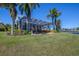 Spacious backyard with screened lanai, leading to a waterfront view, enhanced by lush landscaping at 5321 Fishersound Ln, Apollo Beach, FL 33572
