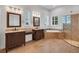 Luxury bathroom with and sinks, soaking tub, glass shower enclosure and travertine tile at 5321 Fishersound Ln, Apollo Beach, FL 33572