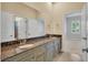 Bathroom featuring granite counters, double sinks, vanity with cabinets and a large mirror at 5321 Fishersound Ln, Apollo Beach, FL 33572