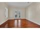 Sunny bedroom with hardwood floors, white trim, and double doors to outside at 5321 Fishersound Ln, Apollo Beach, FL 33572