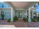 Inviting covered entryway with elegant columns and a bright green front door at 5321 Fishersound Ln, Apollo Beach, FL 33572