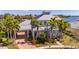 Stunning waterfront home featuring a metal roof, mature palms, and well-maintained landscaping at 5321 Fishersound Ln, Apollo Beach, FL 33572