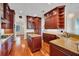 Gourmet kitchen featuring wood cabinets, granite countertops, island with sink, and modern appliances at 5321 Fishersound Ln, Apollo Beach, FL 33572