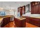 Modern kitchen featuring stainless steel appliances, island with sink, wood cabinets, and granite countertops at 5321 Fishersound Ln, Apollo Beach, FL 33572