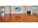 Open living room with hardwood floors, fireplace, and TV at 5321 Fishersound Ln, Apollo Beach, FL 33572