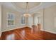 Elegant living room with tray ceiling, hardwood floors and decorative chandelier at 5321 Fishersound Ln, Apollo Beach, FL 33572
