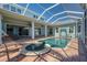 The pool with a hot tub sits next to an outdoor kitchen and overlooks the waterfront at 5321 Fishersound Ln, Apollo Beach, FL 33572