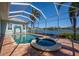 Enclosed pool area with a relaxing hot tub overlooking a waterfront view and lush tropical landscaping at 5321 Fishersound Ln, Apollo Beach, FL 33572
