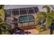 Aerial close up of the screened-in pool and hot tub featuring brick pavers and tropical landscaping at 5321 Fishersound Ln, Apollo Beach, FL 33572