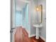 Stylish powder room features a pedestal sink, unique lighting fixture, and hardwood floors at 5321 Fishersound Ln, Apollo Beach, FL 33572