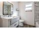 Modern bathroom with a white vanity, sleek fixtures, marble accents in the tiled shower and floors at 5419 Cyril Dr, Dade City, FL 33523