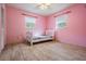This is an empty bedroom with pink walls, tile floors, one single bed and natural light at 5419 Cyril Dr, Dade City, FL 33523