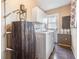This laundry room features a modern washer and dryer set with matching white cabinets and a unique, decorative barrel at 5419 Cyril Dr, Dade City, FL 33523