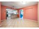 Spacious living room with tile flooring connected to an open concept kitchen with white cabinetry and a center island at 5419 Cyril Dr, Dade City, FL 33523