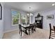 Dining room features a dark wood table, upholstered chairs, elegant chandelier, and large window with natural light at 5611 S Russell St, Tampa, FL 33611