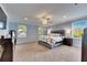 Spacious main bedroom featuring plush carpeting, lots of natural light, and a ceiling fan at 5611 S Russell St, Tampa, FL 33611